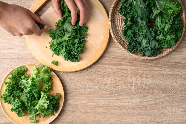 istock Green Kale or leaf cabbage cutting on wooden board, Healthy vegetable, Table top view 1460687489