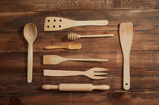 Various wooden kitchen tools on wooden background