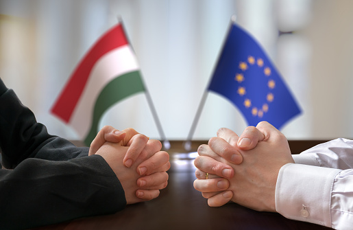 Negotiation between Hungary and European Union. Hungarian and European flags in background.