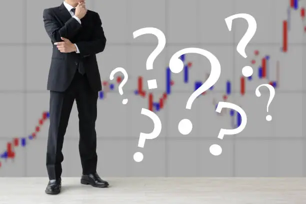 Photo of Thinking investor surrouded by question marks