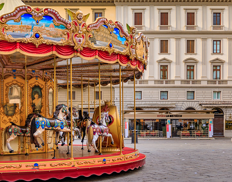 Florence, Italy - June 04, 2022: Ornate antique carousel with wooden horses on Piazza della Republica during the day