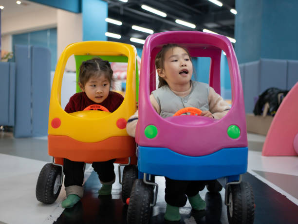 istock Asian child driving a toy car 1460696195