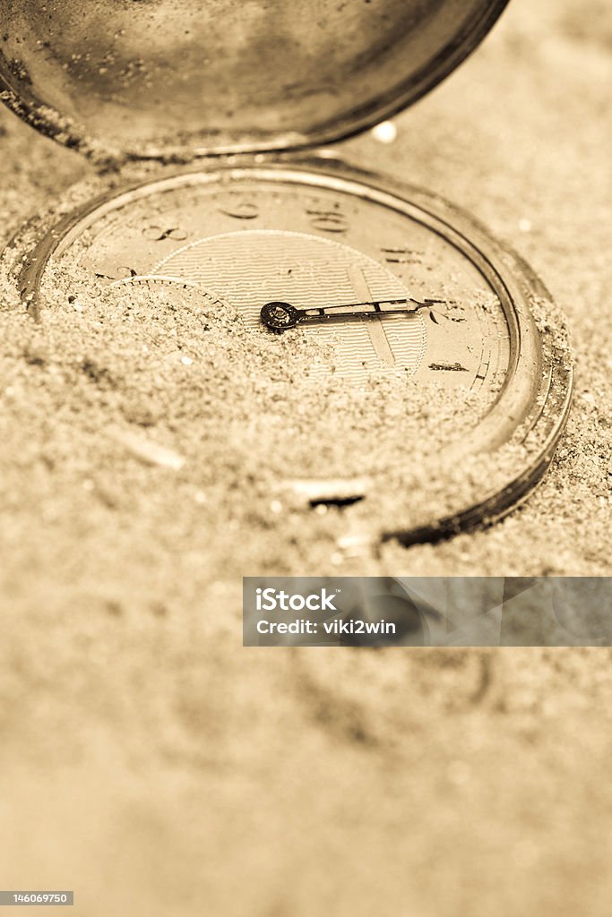 Lost time Old pocket watch buried in sand. Lost time concept. Toned image. Abandoned Stock Photo