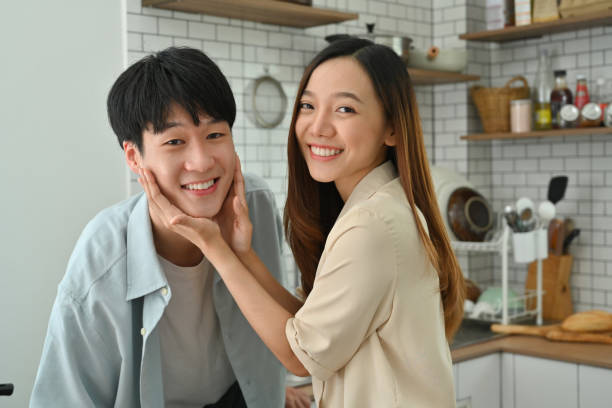 istock Beautiful young couple enjoying spending time together while standing in modern kitchen. 1460697935