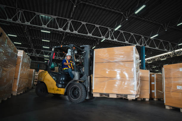 istock Warehouse worker workers with forklift in a warehouse. Use forklift operator moves packages. Concept industrial and commercial. 1460699302