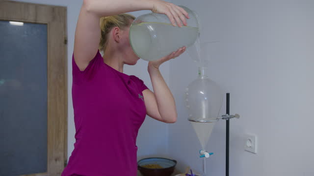 Woman pours liquid into separating funnel