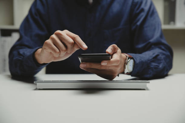 istock Hand of young business using smart phone at home office. 1460701393