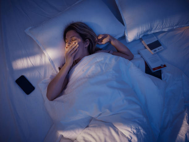 ベッドであくびをしている疲れた女性の上のビュー。 - 睡眠 ストックフォトと画像