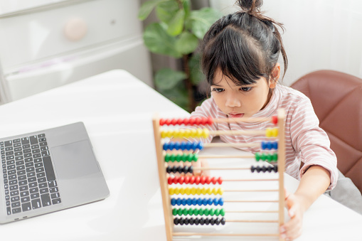 Asian Using Abacus For Math A Young Cute Asian Girl Is Using The Abacus With Colored Beads To Learn ...
