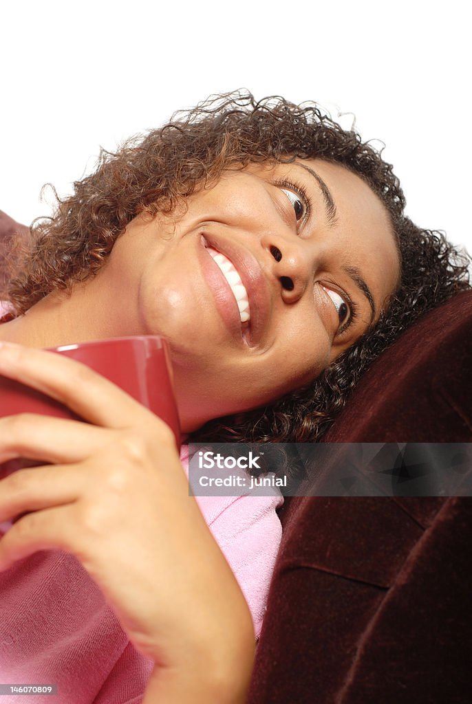 Morning coffee Young woman having her morning cup of coffee on the couch and laughing African-American Ethnicity Stock Photo