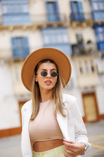 Stylish young woman walking in old Mediterranean town