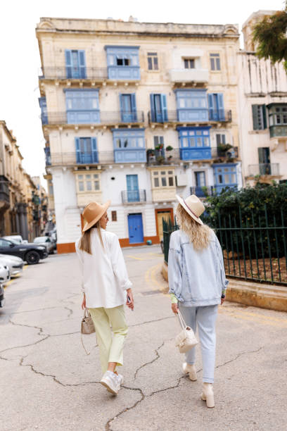 istock Cheerful female friends talking and laughing while exploring old Mediterranean town on sunny day 1460710209