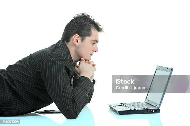 Joven Trabajando En Una Computadora Portátil Foto de stock y más banco de imágenes de 20 a 29 años - 20 a 29 años, A la moda, Acostado