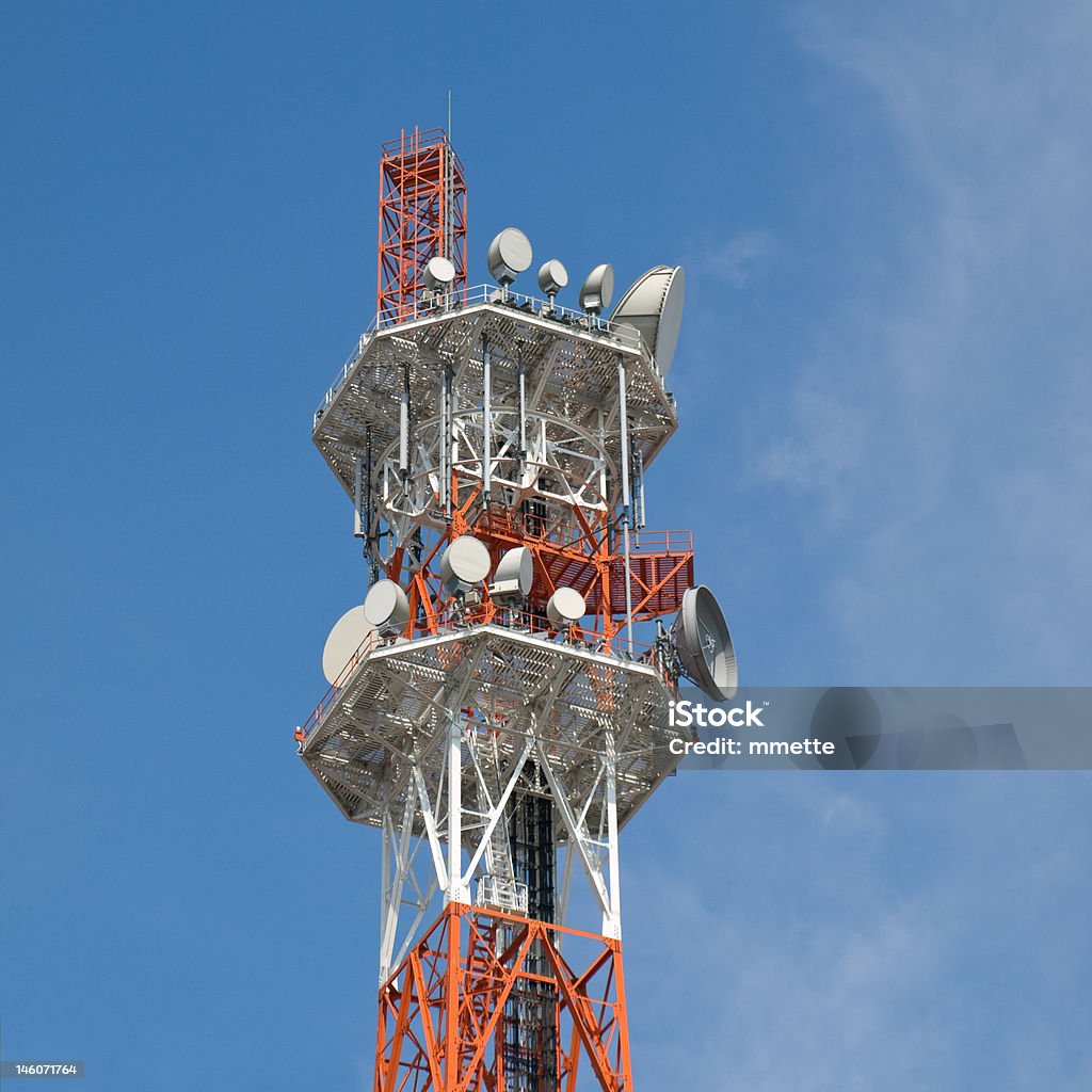 Telecommunications tower Orange and white coloured telecommunications tower with blue sky and thin white clouds in the background Antenna - Aerial Stock Photo