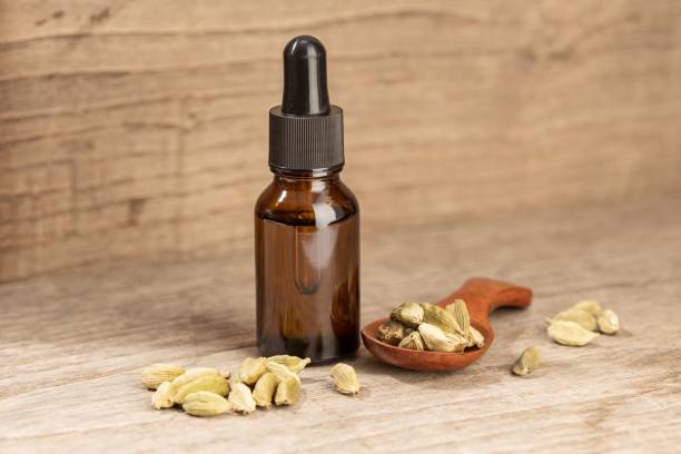 nature morte à l’huile essentielle de cardamome. flacon en verre ambré avec pipette - cardamome huile essentielle photos et images de collection