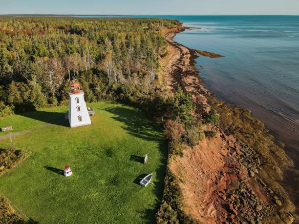 istock Beautiful view of a forest on a cliff with a lighthouse under the blue sky 1460718508