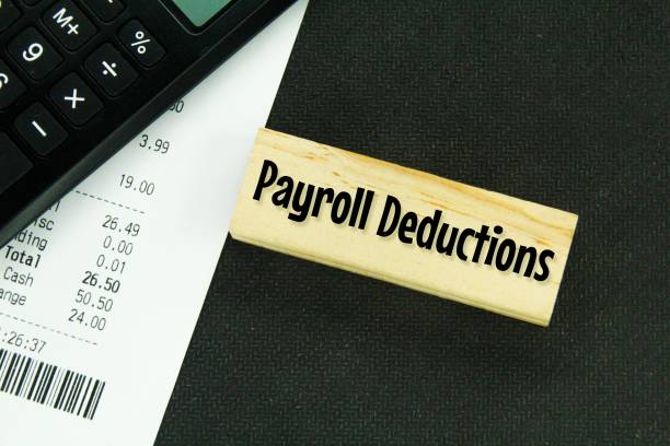 istock calculators, receipts and wooden boards with the word payroll deductions 1460719748