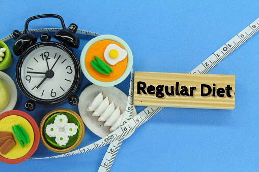 the alarm clock is surrounded by food and wooden boards with the word diet regular concept