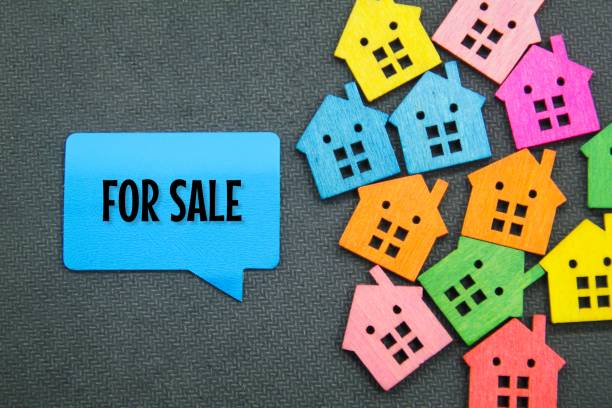 pequeñas casas de colores y cajas de conversación con las palabras for sale. concepto de bienes raíces en venta - sign real estate foreclosure for sale fotografías e imágenes de stock