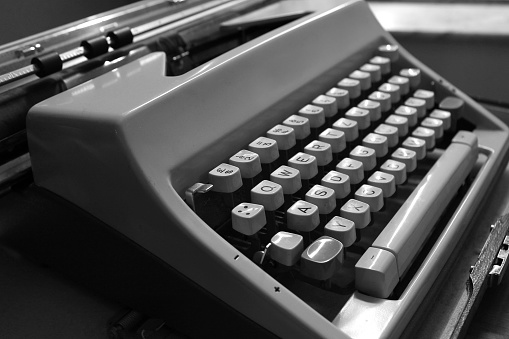 A grayscale closeup shot of details on a vintage typewriter