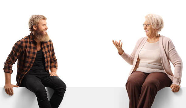 istock Young bearded man sitting on a white panel board and talking with an older woman 1460723044