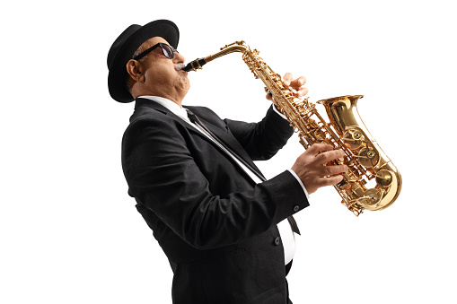 Profile shot of a mature elegant musician playing sax isolated on white background