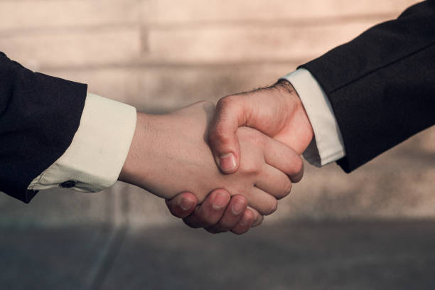 Man and woman hand shaking on nature background