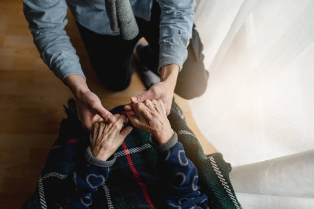 istock Caring grandson holding grandmother's hands 1460724127