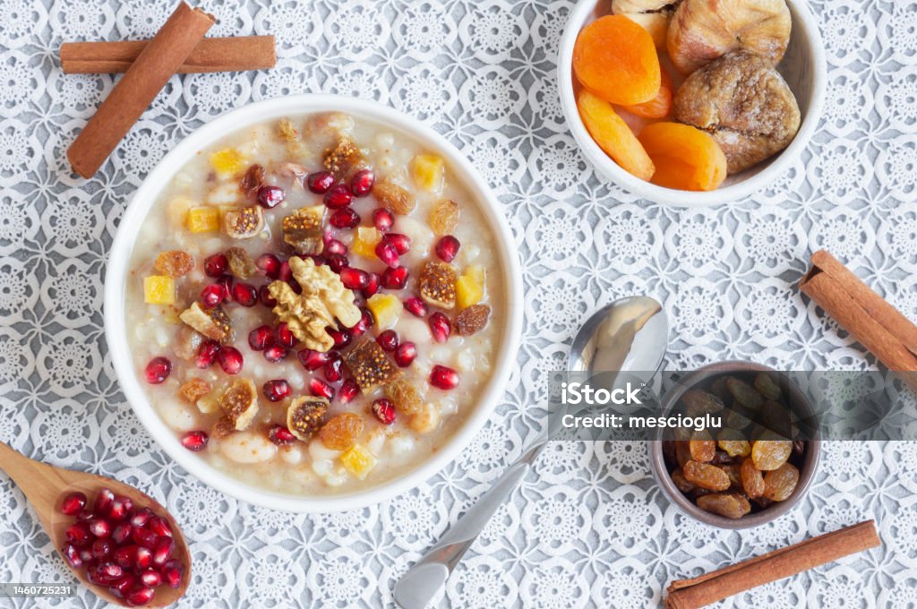 Traditional Turkish delicious mixed dessert, ashura (asure) with pomegranate seeds, walnut, apricot, Noah’s pudding Apricot Stock Photo