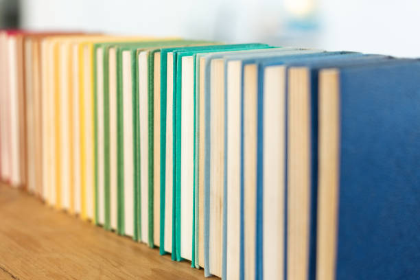 istock Closeup of stacked colorful books on different fields on the table with a blurry background 1460725567