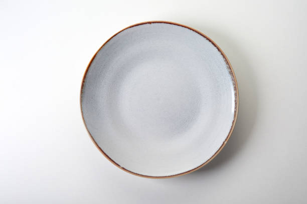 istock Top view of a ceramic plate with a brown brim for lunch on white background 1460726255