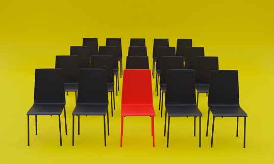 A 3d rendering of a set of black chairs where a red one stands out on a yellow background.