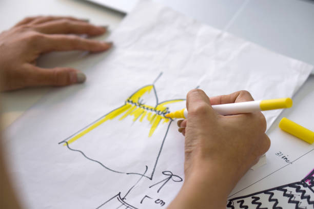 istock Closeup fashion designer hand use magic pen painting on pattern for cloth. 1460727729