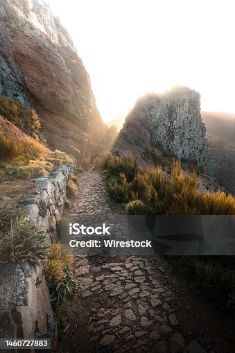 istock Vertical shot of a narrow rock path on the mountain slope at sunrise 1460727883
