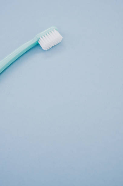 istock Vertical top view of a blue toothbrush on a pastel blue surface for a copy space 1460729186