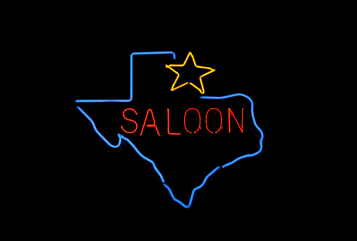 A glowing blue neon outline of Texas with red text saying \