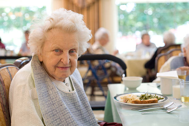 happy elderly woman de disfrutar de una comida, 1 - care community 80 plus years cheerful fotografías e imágenes de stock