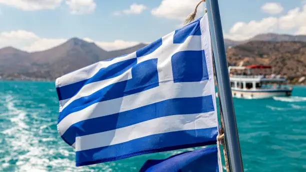 A waving flag of Greece on a ship off the Greek coast