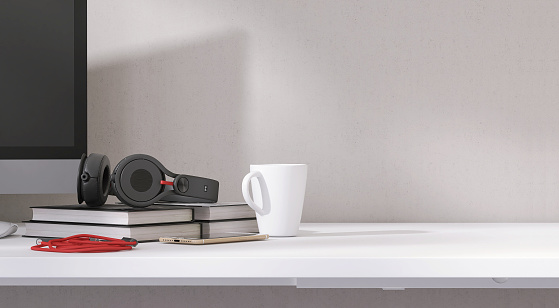 Modern, minimal white working desk with computer desktop, books, headphone, smartphone and coffee cup in bedroom in  sunlight from window on blank wall for luxury lifestyle product display 3D