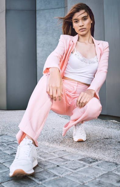 istock Young trendy and confident mixed race woman looking stylish while posing and spending time in the city. Fashionable young hispanic woman wearing pink clothes and enjoying time in the city 1460732808