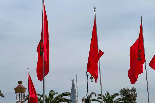 istock Moroccan flags fluttering with a cloudy sky in the background 1460736316