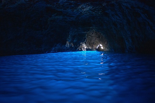 A view of a sailing boat on the water in the cave on Capri Island, Naples, Italy