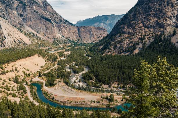 istock Bird's eye view of a river in a valley surrounded by forests and mountains 1460737575