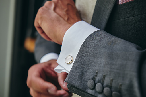 A closeup shot of a man wearing a suit for a wedding