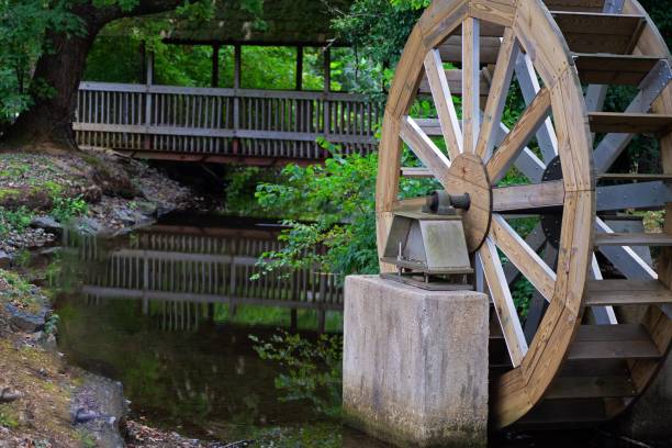 istock Old working watermill in a park surrounded by trees 1460739755