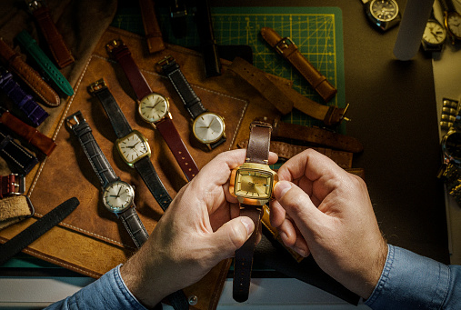 Watch collector is adjusting the mechanical watch in his workshop
