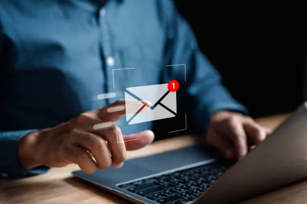 Photo of Businessman sending email by laptop computer to customer, business contact and communication, email icon, email marketing concept, send e-mail or newsletter, online working internet network.