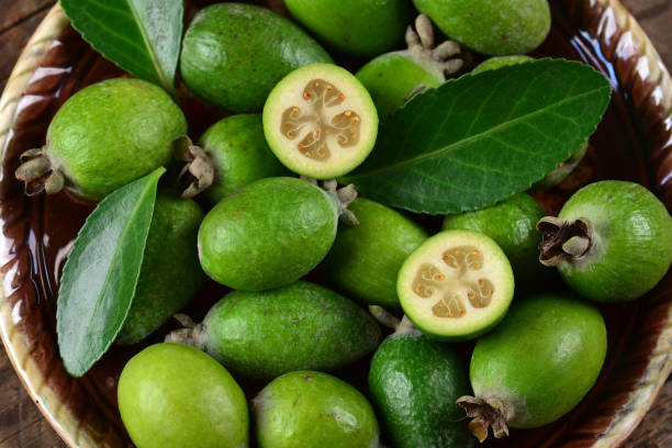 Top view of Feijoa fruits with sliced on a plate on a wooden table A top view of Feijoa fruits with sliced on a plate on a wooden table pineapple guava stock pictures, royalty-free photos & images