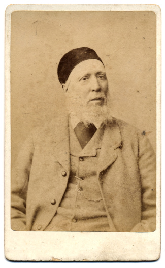 Victorian Era's Portrait on a Card , A man with big beard and Turkish Hat (Fez) in suit. Shot in England circa 1880