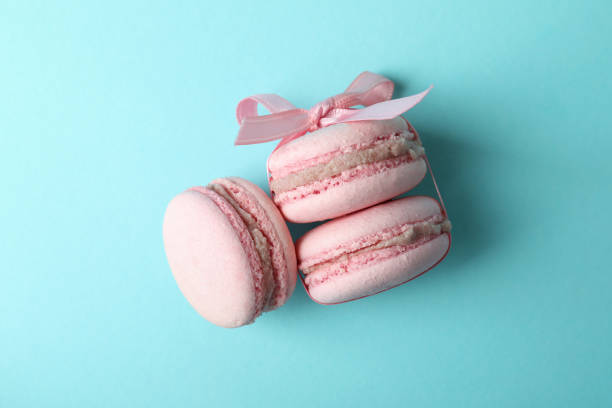Concept of tasty dessert with macaroons on blue background